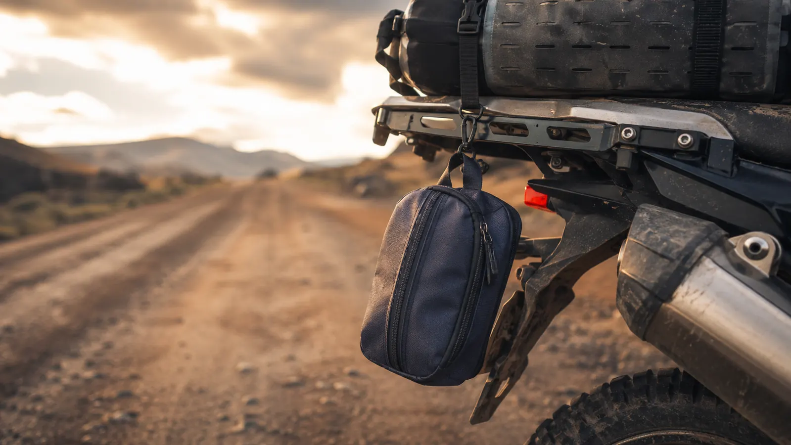 BAGSMART toiletry bag hanging from a motorcycle handlebar bag hook during a cross-country road trip