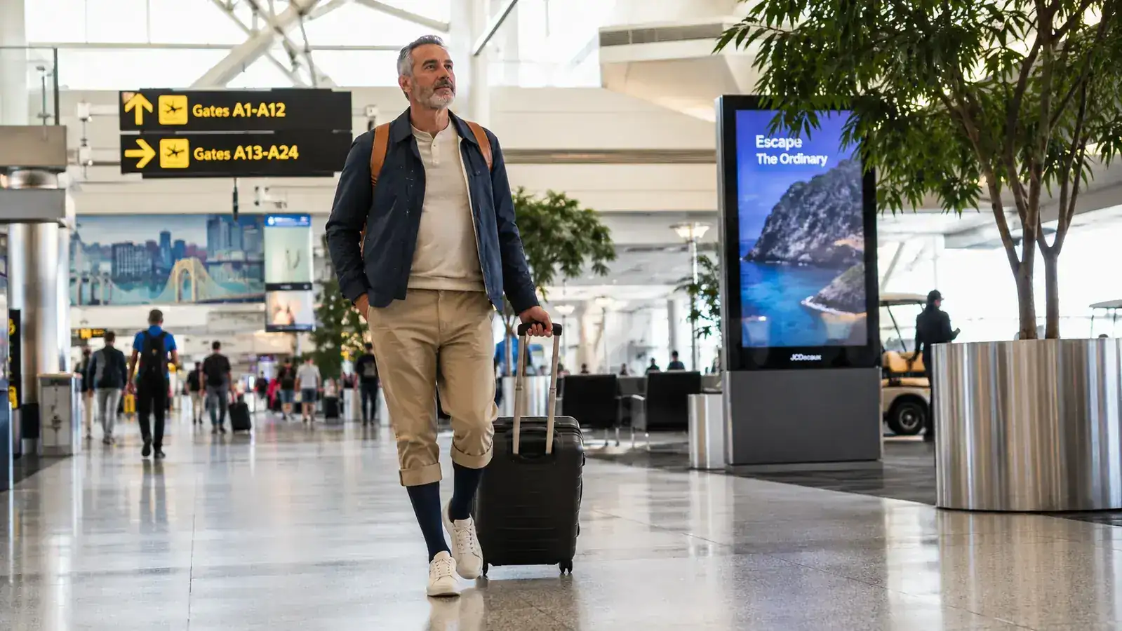Traveler walking across an airport terminal in compression socks after a long flight, looking comfortable