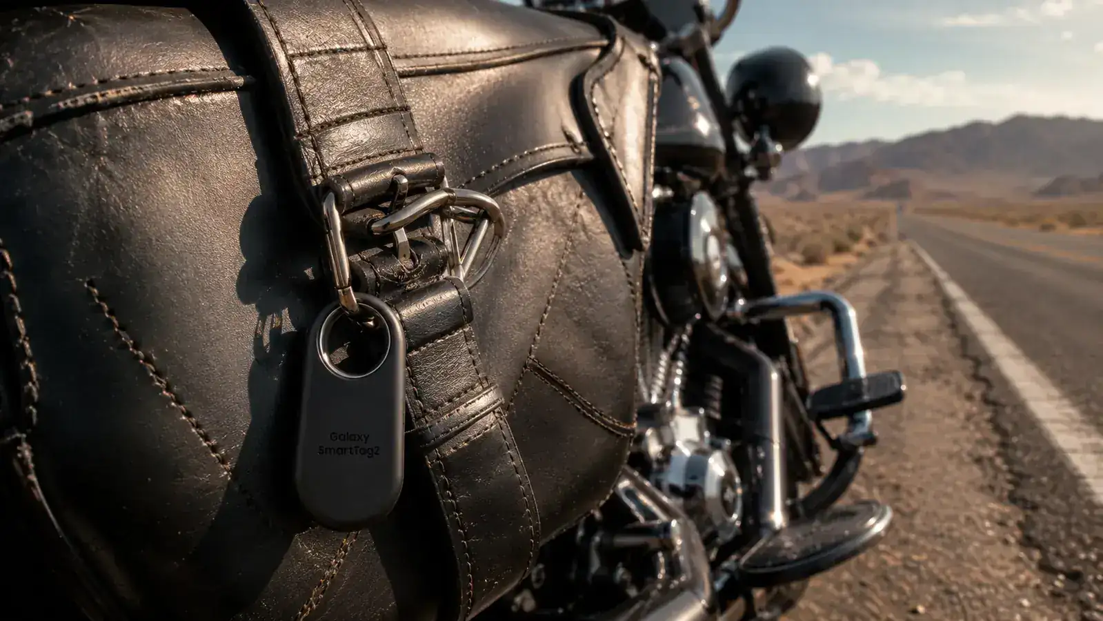 SmartTag2 attached to a motorcycle saddlebag strap on a desert highway